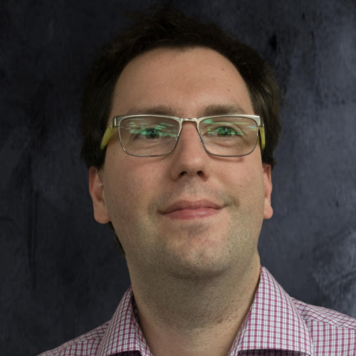 Headshot of Ryan in front of a generic photo backdrop.